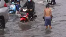 Pengendara terjebak banjir yang menggenangi jalan Bayangkara Pusdiklat, Kota Tangerang Selatan, Banten, Selasa (2/11/2021). BMKG mengeluarkan peringatan potensi cuaca ekstrem di wilayah Jakarta, Bogor, Depok, Tangerang, dan Bekasi (Jabodetabek). (Liputan6.com/Angga Yuniar)