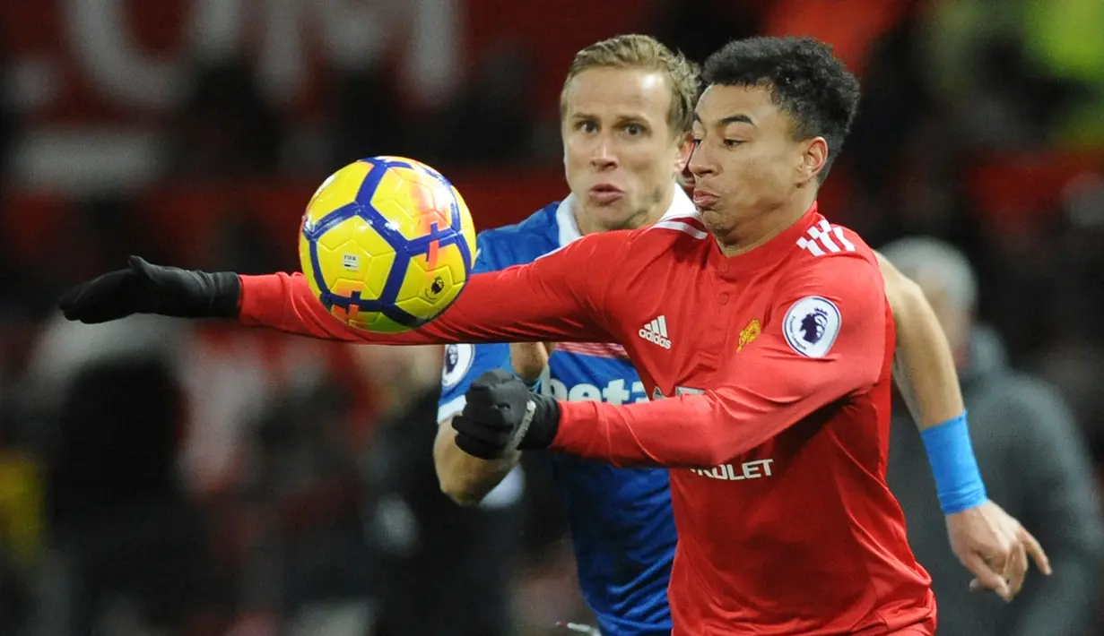 Pemain Manchester United, Jesse Lingard, berebut bola pemain Stoke City, Moritz Bauer pada laga pekan ke-23 Premier League 2017-2018 di Old Trafford, Senin (15/1). Manchester United melibas Stoke City 3-0 di kandang sendiri. (AP/Rui Vieira)