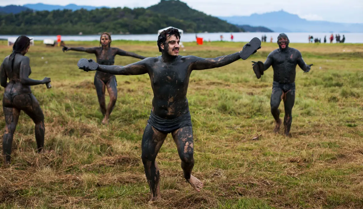 Sejumlah peserta dengan tubuh yang dipenuhi lumpur menari saat mengikuti festival tradisional "Bloco da Lama" atau "Mud Street" di Paraty, Brasil (25/2). (AP Photo / Mauro Pimentel)