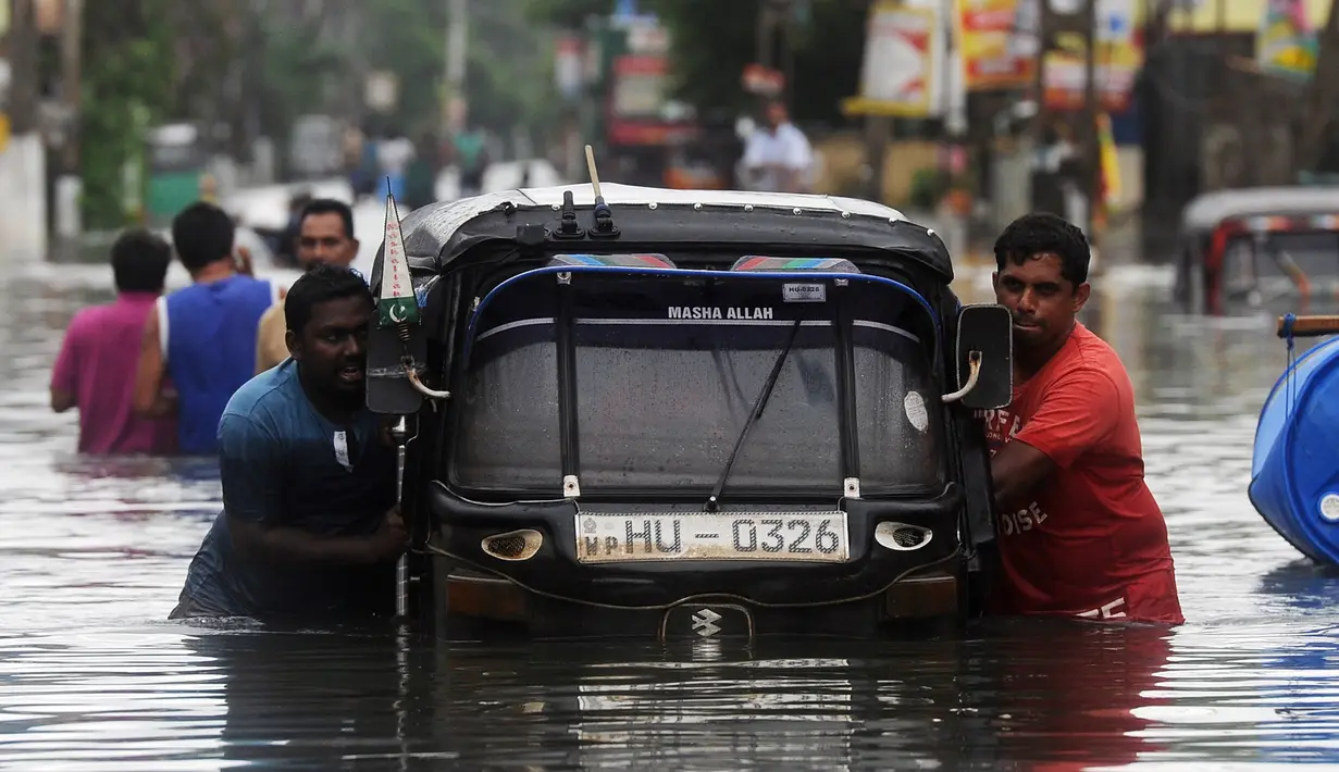 Warga mendorong bajaj saat banjir melanda kawasan mereka di Kaduwela, Kolombo, Sabtu (21/5/2016). Dikabarkan sekitar 80 orang tewas akibat hujan dan tanah longsor yang melanda Sri Lanka. (AFP Photo/Lakruwan W)