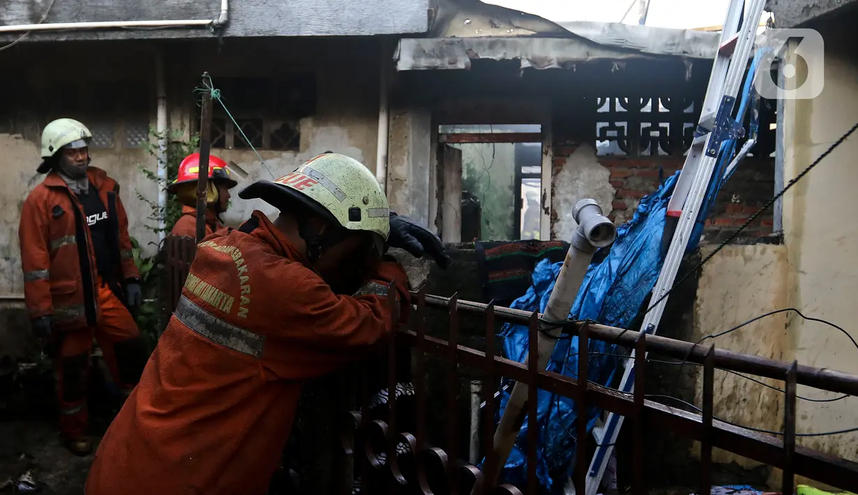 Petugas pemadam kebakaran saat melakukan pendinginan usai kebakaran melanda pemukiman padat penduduk di kawasan Peninggaran Timur, Kebayoran Lama, Jakarta, Senin (27/1/2019). Kebakaran menewaskan satu orang pria akibat terjebak dalam kamar. (Liputan6.com/Johan Tallo)