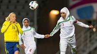 Foto Olahraga Terbaik - Pesepak bola Iran, Koyestan Khosravi, membuang bola dari kejaran pemain Swedia, Petra Andersson,  pada laga persahabatan sepak bola putri di Gothenburg, Swedia, Jumat (21/10/2016). (EPA/Thomas Johansson)