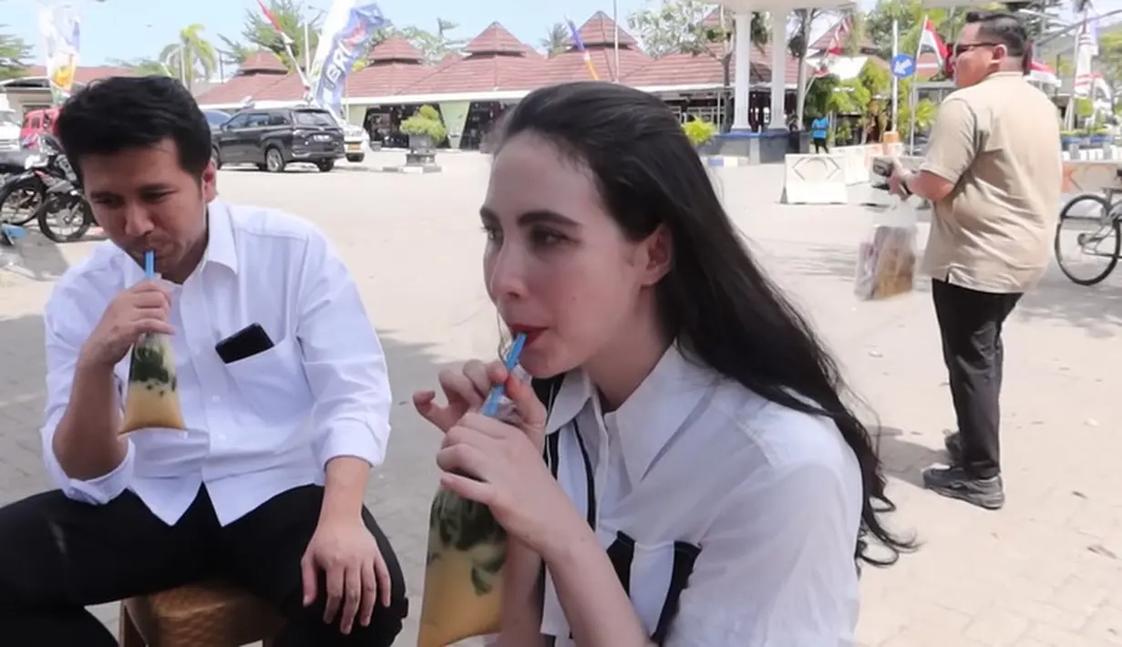 Sebelum kembali ke Surabaya, Arumi Bachsin dan Emil Dardak menikmati es dawet di depan pasar. Santai minum es di dalam plastik. [Youtube/Arumi Bachsin]