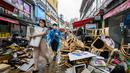 Pejalan kaki berjalan melewati puing-puing di luar toko-toko di Pasar Namseong yang bersejarah di distrik Gangnam Seoul (9/8/2022). Presiden Korea Selatan meminta agar jajarannya siap untuk melawan dampak lebih lanjut dari banjir di wilayah Seoul dan sekitarnya, seperti tanah longsor.
