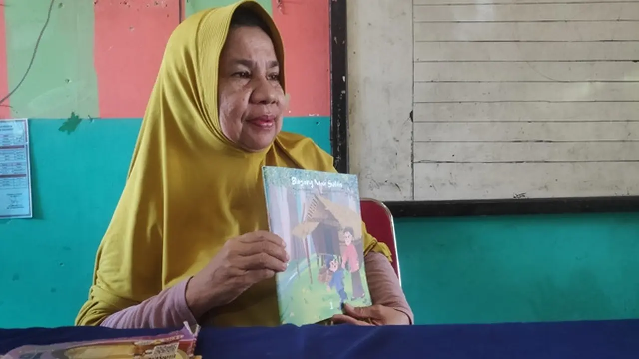 Hasmawati, guru SDN 153 Pekanbaru memperlihatkan buku yang dikarangnya.