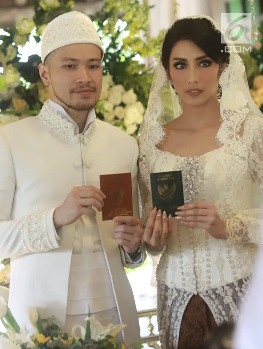 Aktris Tyas Mirasih dan suaminya Raiden Soedjono menunjukkan buku pernikahan usai ijab kabul di kawasan Cilandak, Jakarta (8/7). Tyas Mirasih menikah dengan Raiden Soedjono dengan mas kawin perhiasan emas delapan gram. (Liputan6.com/Herman Zakharia)