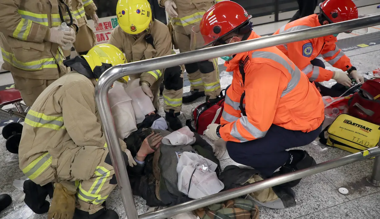 Seorang korban kebakaran sedang menerima pertolongan dari tim medis di Stasiun Tsim Sha Tsui, Hong Kong (10/2). Sedikitnya 17 orang mengalami cedera akibat kebakaran di sebuah kereta bawah tanah Hong Kong ini. (Handout / Apple Daily / AFP)
