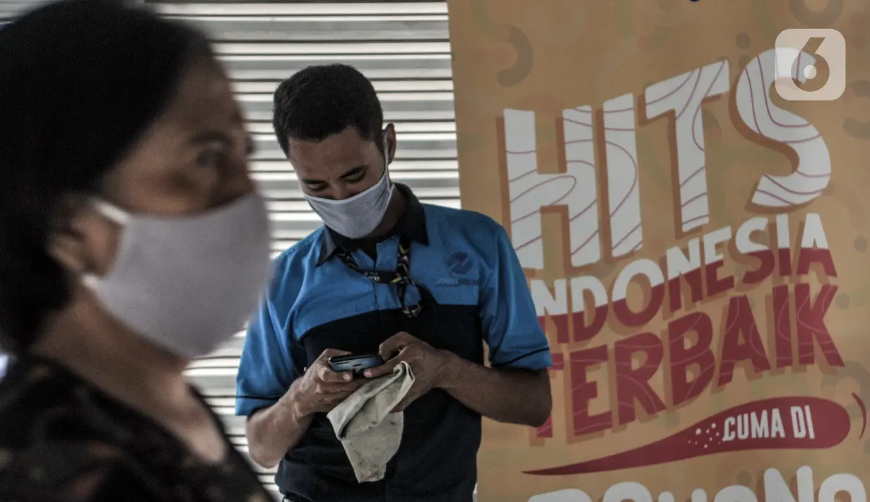 Calon penumpang mengoperasikan telepon genggam di Halte Harmoni, Jakarta, Senin (16/11/2020). PT Transjakarta memperluas penyediaan fasilitas wifi gratis berkecapatan tinggi. (merdeka.com/Iqbal S. Nugroho)