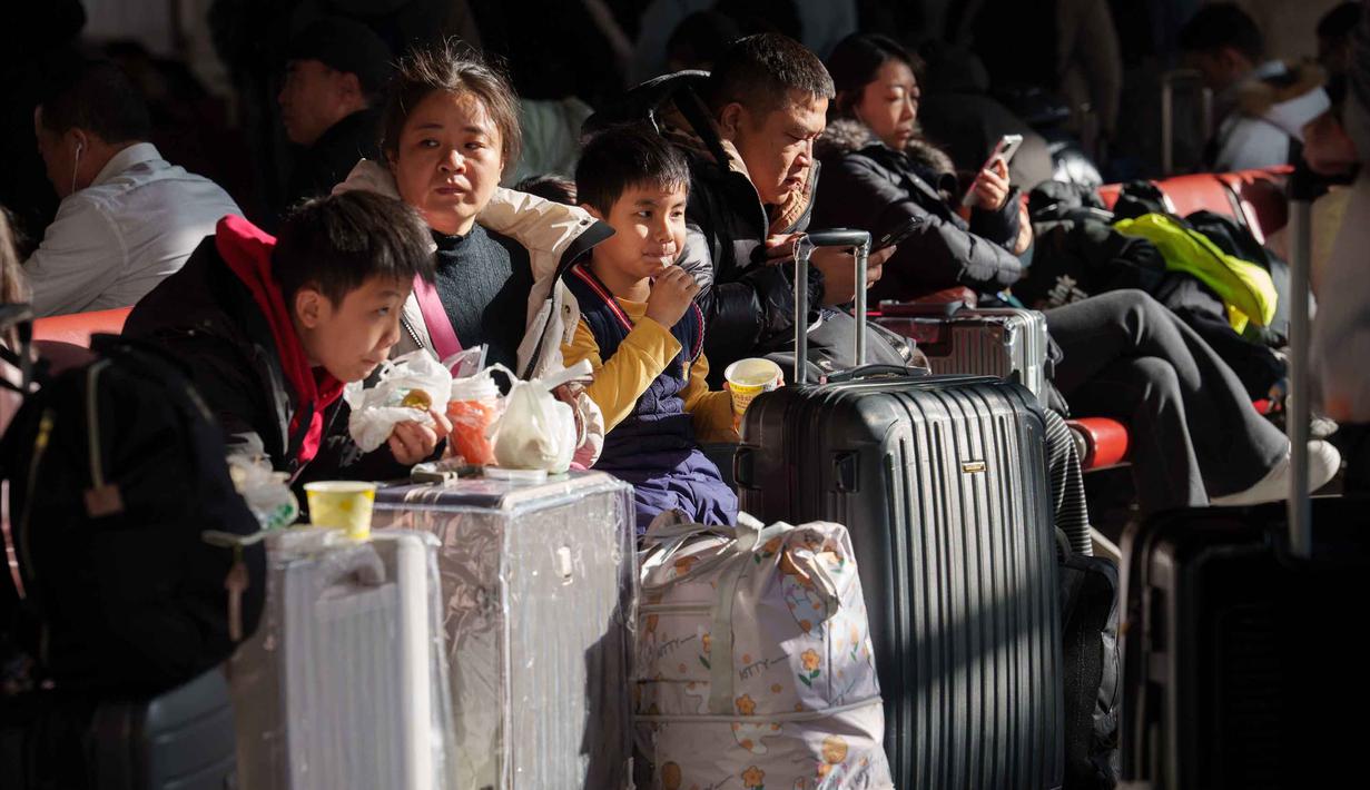 Otoritas transportasi China memprediksi, ada sekitar 9,5 miliar perjalanan penumpang akan dilakukan selama periode arus mudik yang akan berakhir pada 13 Maret 2026. Tampak dalam foto, para penumpang duduk di samping barang bawaan mereka sambil menunggu di stasiun kereta api dalam perjalanan pulang selama liburan Tahun Baru Imlek di Beijing, China, Selasa 10 Februari 2026. (AP Photo/Vincent Thian)