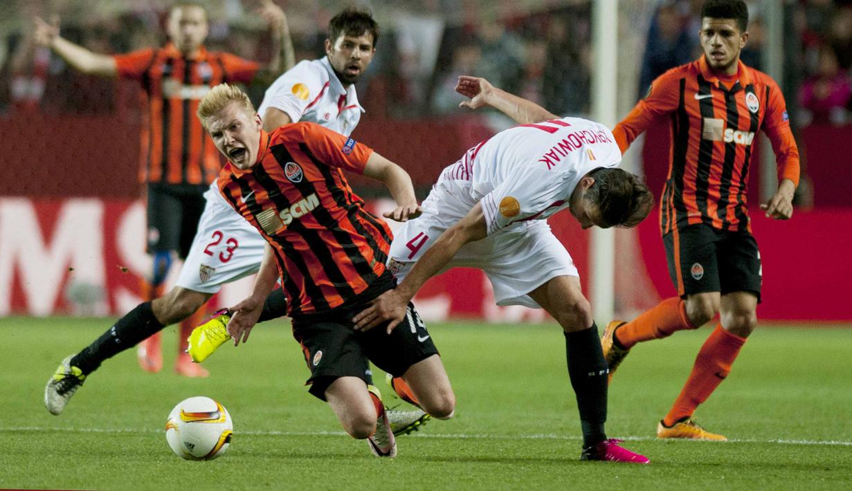 Pemain Shakhtar Donetsk, Viktor Kovalenko (kiri)  terjatuh saat berebut bola dengan pemain Sevilla, Grzegorz Krychowiak dpada leg kedua semifinal Liga Europa di Stadion Ramon Sanchez Pizjuan, Sevilla, Jumat (6/5/2016) dini hari WIB. (AFP/Jorge Guerrero)