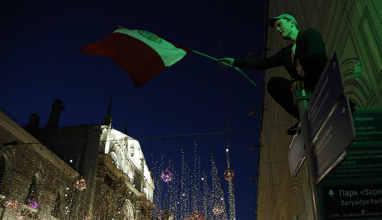 Suporter Peru mengibarkan bendera sombrero menyambut gelaran Piala Dunia di Jalan Nikolskava, Moskow, Rabu (13/6/2018). Piala Dunia 2018 akan berlangsung pada 14 Juni hingga 15 Juli mendatang. (AP/Rebecca Blackwell)
