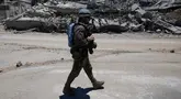 Seorang pasukan penjaga perdamaian Perserikatan Bangsa Bangsa (PBB) asal Spanyol melewati sebuah rumah yang hancur dalam bentrokan antara Hizbullah dan militer Israel di desa Dibbine, Lebanon Tenggara, Jumat 5 Juni 2026. (AP Photo/Hussein Malla)
