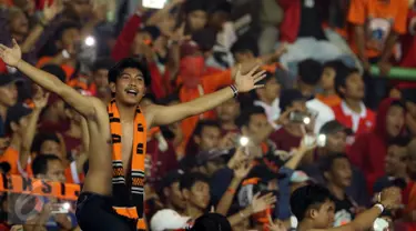 Suporter membentangkan tangan usai menyaksikan laga Persija melawan Timnas Indonesia U-22 di Stadion Patriot Candrabhaga, Bekasi, Rabu (5/4). Laga Persija melawan Timnas Indonesia U-22 berakhir imbang 0-0. (Liputan6.com/Helmi Fithriansyah)