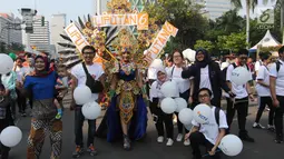 Karyawan PT Elang Mahkota Teknologi (Emtek) menjadi peserta parade Asian Games 2018 di Jalan Thamrin, Jakarta, Minggu (13/5). Perwakilan Emtek menggunakan kaos putih sambil membawa balon-balon putih. (Liputan6.com/Arya Manggala)