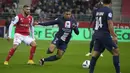 Penyerang Paris Saint-Germain (PSG) Kylian Mbappe menjauh dari penyerang Reims Arber Zeneli dalam pertandingan pekan ke-10 Liga Prancis di Stade Auguste-Delaune II, Minggu (9/10/2022) dini hari WIB. Dalam laga ini, Lionel Messi absen karena cedera betis dan Sergio Ramos mendapat kartu merah. (AP Photo/Michel Euler)