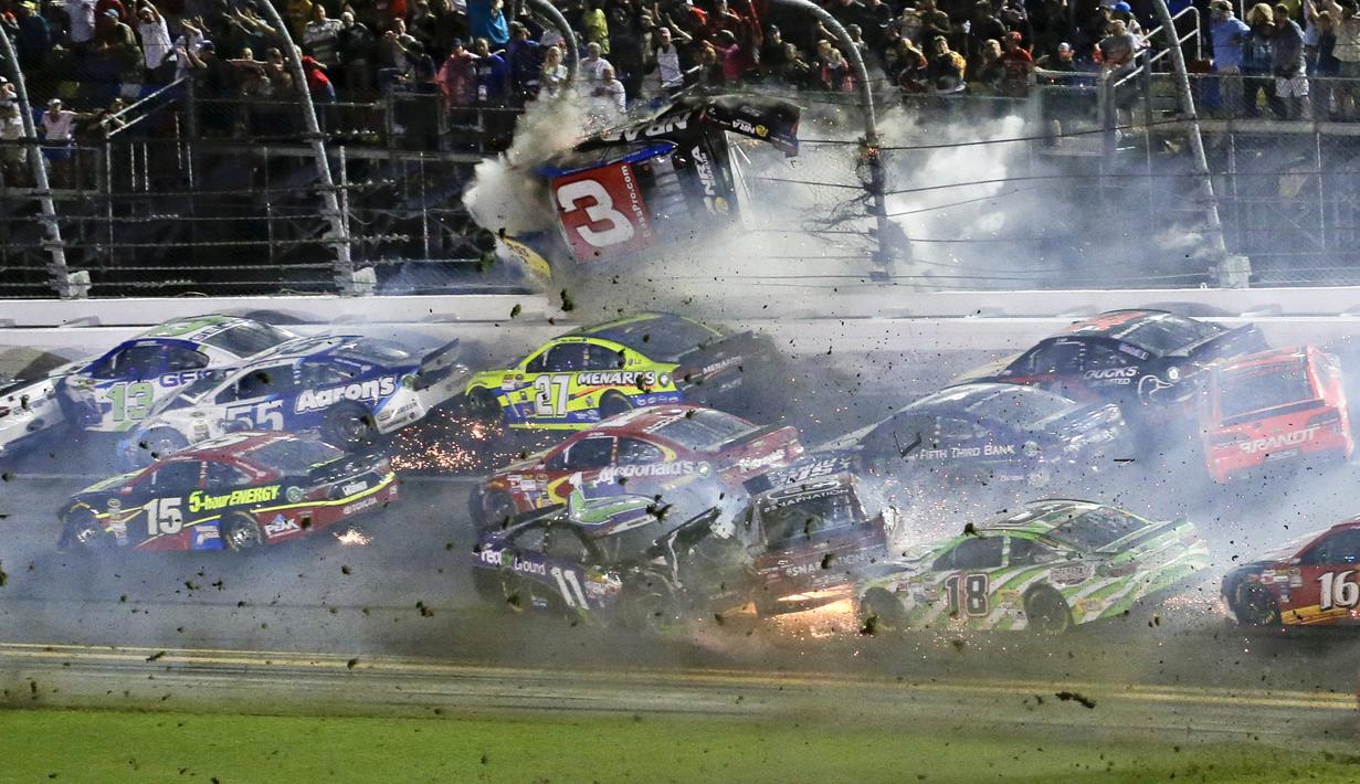 Mobil Austin Dillon terbang dan tersangkut di pagar pembatas. (AP Photo)