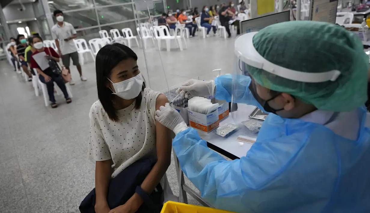 Seorang petugas kesehatan menyuntikkan dosis vaksin COVID-19 Pfizer kepada warga di pusat vaksinasi di Bangkok, Thailand, Jumat (4/2/2022). (AP Photo/Sakchai Lalit)