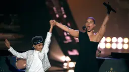 Penyanyi Alicia Keys mengangkat tangan putranya Egypt Dean selama acara iHeartRadio Music Awards 2019 di Los Angeles, California, AS (14/3).  Alicia Keys membawakan lagu Raise a Man dan You Don't Know My Name. (AP Photo/Chris Pizzello)