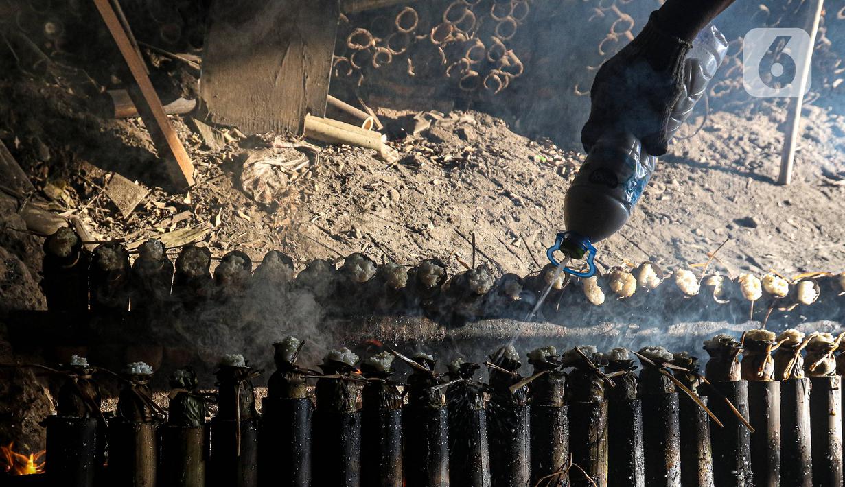 Pekerja melakukan pembakaran lemang bambu di Jalan Kramat Raya, Senen, Jakarta Pusat, Rabu (6/4/2022). Selama Ramadhan, pembuat lemang mampu memproduksi hingga 300 buah dalam sehari, meningkat hingga tiga kali lipat dari hari biasa. (Liputan6.com/Herman Zakharia)