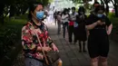 Warga mengenakan masker menunggu dalam barisan untuk tes virus corona di lingkungan di Wuhan, provinsi Hubei, Jumat (15/5/2020). Tes massal yang ditargetkan dalam 10 hari ini akibat adanya pasien Virus Corona baru di Wuhan, setelah sebulan lebih tidak ada laporan kasus baru. (Hector RETAMAL/AFP)