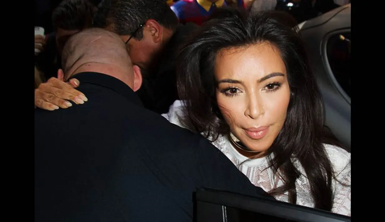 Meskipun langsung dihadang oleh pengawalnya yang mengenakan jas hitam tapi Kim Kardashian sempat terdorong ke sisi mobil, Paris, (25/9/14). (Dailymail)