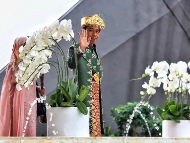 Presiden Joko Widodo atau Jokowi (kanan) beserta Ibu Iriana Joko Widodo (kiri) melambaikan tangan saat tiba di Gedung Nusantara MPR/DPR/DPD RI, Jakarta, Selasa (16/8/2022). Presiden Jokowi akan menyampaikan pidato kenegaraan di Gedung MPR/DPR/DPD RI. (Liputan6.com/Angga Yuniar)
