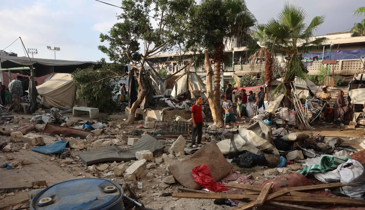 Pengungsi Palestina menyelamatkan sebagian barang-barang mereka di tengah puing-puing, di halaman Sekolah al-Farabi yang telah berubah menjadi tempat penampungan bagi para pengungsi, setelah diserang oleh serangan Israel, di Kota Gaza, bagian utara Jalur Gaza, pada 7 September 2025. (Omar AL-QATTAA/AFP)