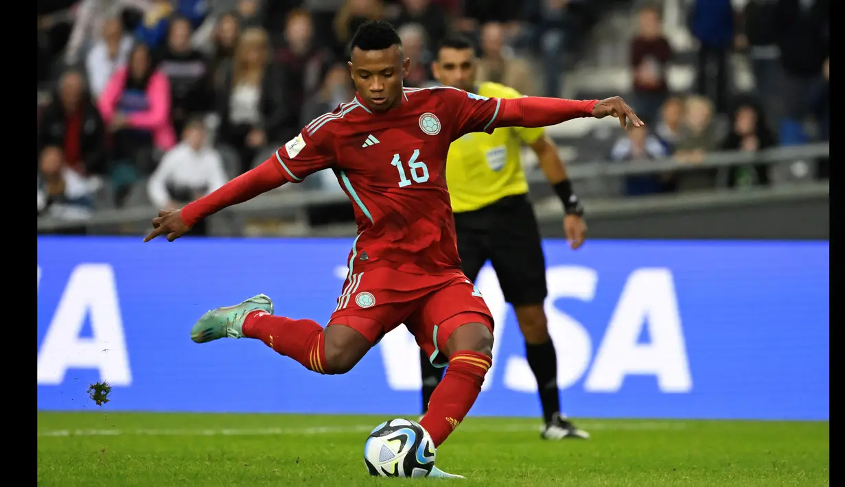 Pemain Timnas Kolumbia U-20, Oscar Cortes menendang bola dari titik penalti yang membuahkan gol ke gawang Israel dalam pertandingan Grup C Piala Dunia U-20 2023 yang berlangsung di Diego Armando Maradona stadium, Argentina, Minggu (21/5/2023). Sampai dengan babak 16 besar Cortes telah mencetak empat gol dan berhasil membawa Kolumbia tampil di perempat final Piala Dunia U-20 2023. (AFP/Luis Robayo)