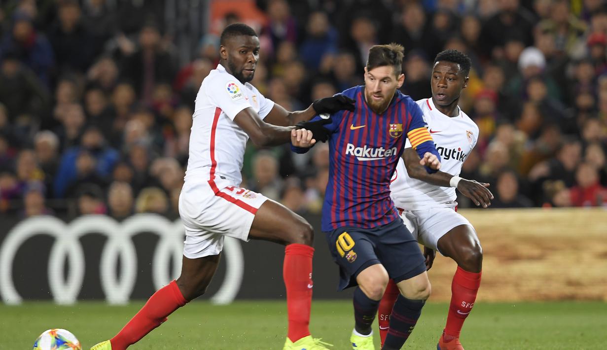 Aksi bintang Barcelona, Lionel Messi melewati dua pemain Sevilla pada leg kedua Copa Del Rey yang berlangsung di stadion Nou Camp, Barcelona, Kamis (31/1). Barcelona menang 6-1 atas Sevilla. (AFP/Luis Gene)