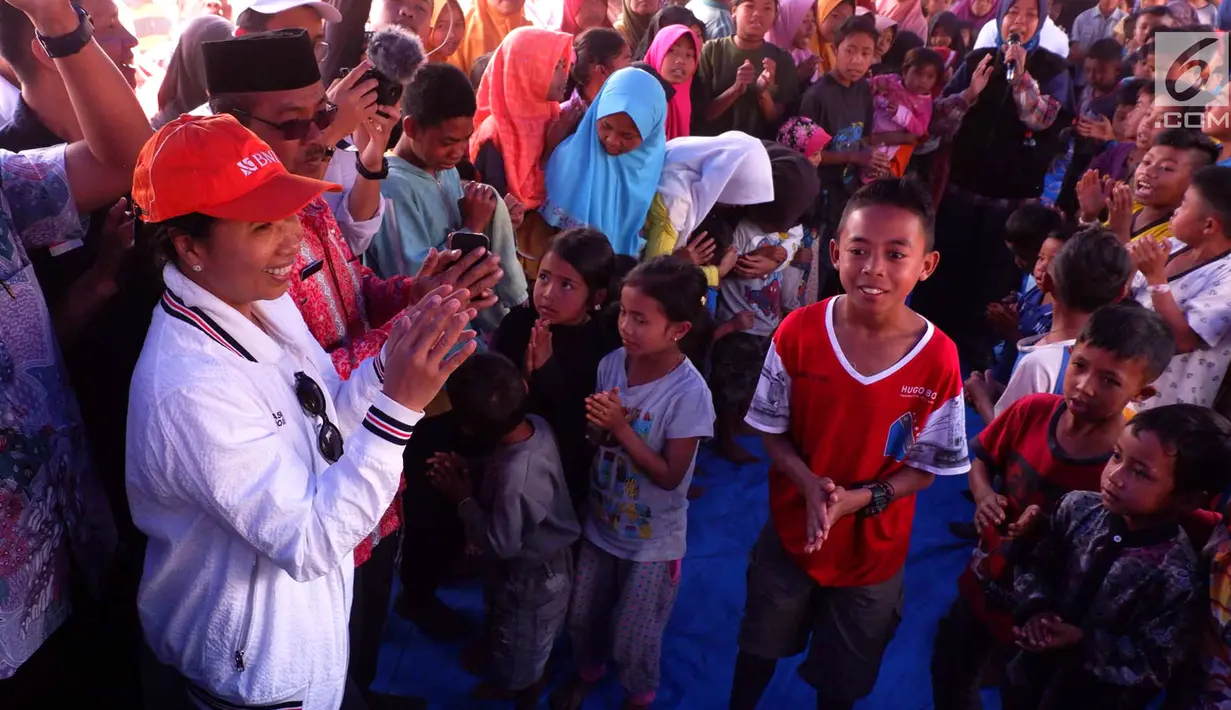 Menteri Badan Usaha Milik Negara (BUMN) Rini Soemarno menghibur anak-anak saat mengunjungi pengungsian di Desa Sembalun Bumbung, Lombok, NTB, Minggu (25/8). Tercatat 50 BUMN menyalurkan bantuan total mencapai Rp 13,2 M, (Liputan6.com/HO/Eko)