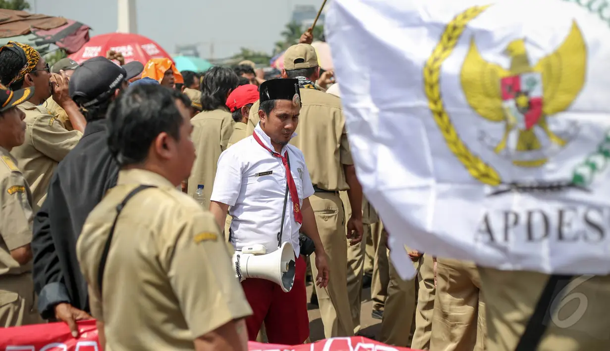 Salah seorang perangkat desa memakai seragam SD saat aksi menuntut pengembalian ‘tanah bengkok’ di depan Istana Negara, Jakarta, Rabu (27/5/2015). (Liputan6.com/Faizal Fanani)