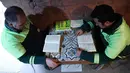 Petugas kebersihan membaca buku di perpustakan tempat mereka bekerja di distrik Cankaya, Ankara, Turki (9/1).Beberapa petugas ini membuat band bernama "Grup Tin", dengan menggunakan tempat sampah dan barang bekas sebagai alat musik. (AFP Photo/Adem Altan)