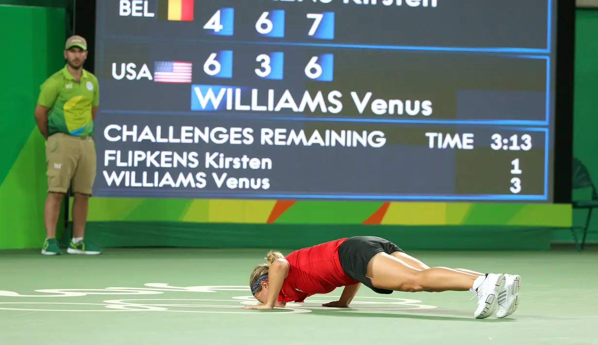 Petenis tunggal putri asal Belgia, Kirsten Flipkens melakukan selebrasi dengan mencium lapangan saat menaklukan petenis putri AS, Venus Williams pada Olimpiade Rio 2016 di Olympic Tennis Centre, Rio de Janeiro, Brazil, (6/8). (REUTERS/Kevin Lamarque)