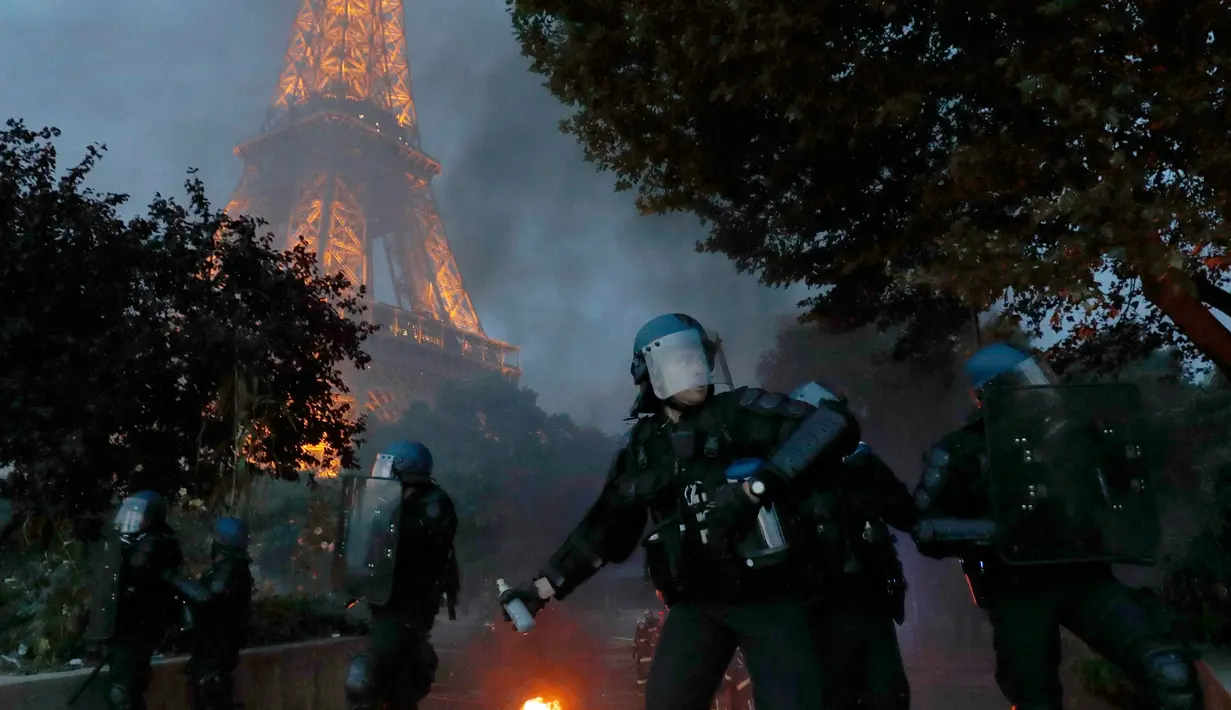 Petugas menembakkan gas air mata saat akan membubarkan demonstran yang mencoba memasuki "fan zone" di bawah Menara Eiffel untuk menonton final EURO 2016 di Prancis (10/6). (REUTERS/Philippe Wojazer)