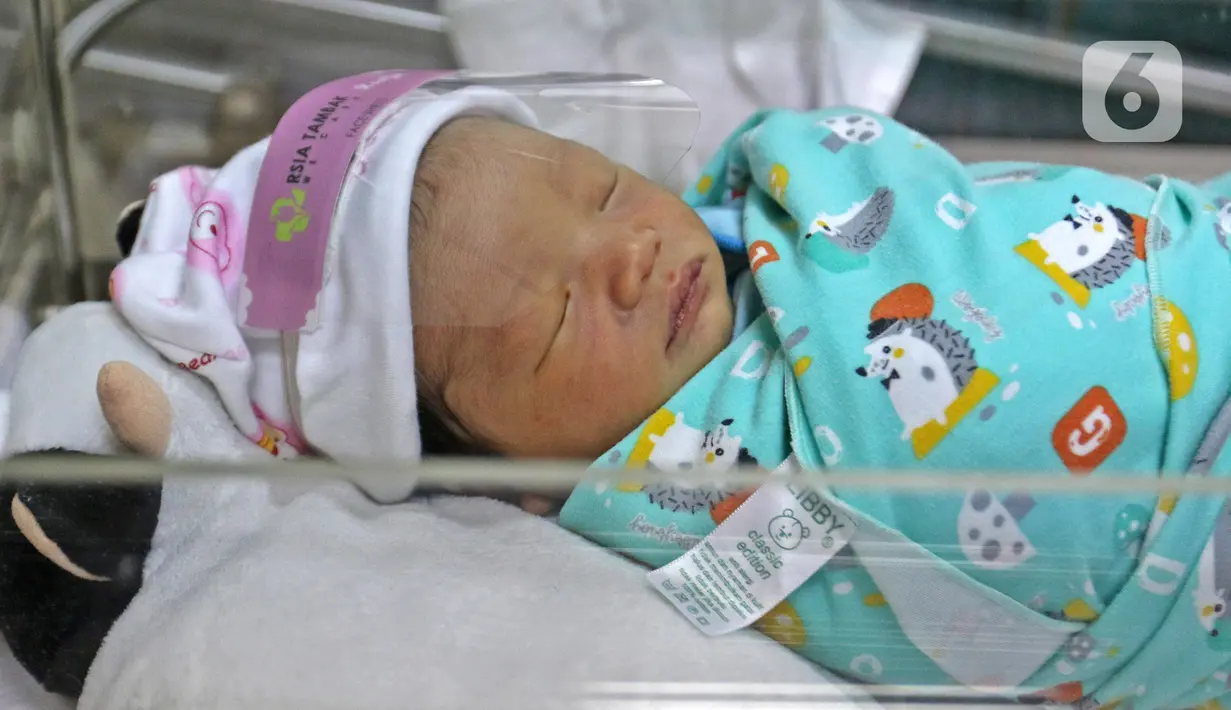 Seorang bayi memakai face shield atau pelindung wajah di Rumah Sakit Ibu dan Anak Tambak, Jakarta, Selasa (14/4/2020). RSIA Tambak sejak 12 April 2020 membuat kebijakan bayi yang baru lahir dipakaikan pelindung wajah untuk mencegah terpapar virus corona COVID-19. (Liputan6.com/Herman Zakharia)