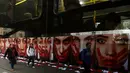 Warga berjalan disamping deretan foto wanita dengan wajah bercat merah di Sao Paulo Art Museum, Brasil , 10 Juni 2016. Ini juga sebagai protes organisasi non -pemerintah yang dinamakan Rio de Paz. (REUTERS / Paulo Whitaker)