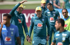 Pelatih kepala Tim Nasional (Timnas) Brasil asal Italia, Carlo Ancelotti (tengah), tersenyum di samping penyerang Raphinha (kanan) selama sesi latihan sebagai bagian dari persiapan menghadapi pertandingan sepak bola Piala Dunia 2026 melawan Maroko di Fasilitas Latihan Columbia Park, Morristown, New Jersey, pada 9 Juni 2026. (MAURO PIMENTEL/AFP)