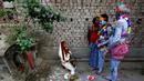 Seorang wanita (kiri) berdoa dihadapan sejumlah umat hindu yang mengecat tubuhnya selama ritual dalam festival keagamaan Siwa Gajan di Bengal Barat , India , (11/4).Kegiatan ini juga menandai akhir tahun kalender Bengali. (REUTERS / Rupak De Chowdhuri)