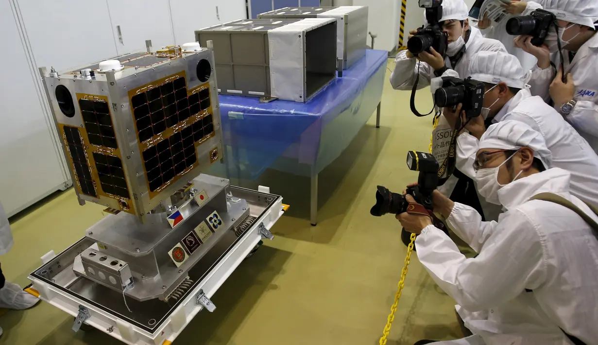 Sejumlah wartawan mengabadikan gambar Diwata - 1 di JAXA Tsukuba Space Center, Jepang, (13/1). Alat ini dirancang oleh orang Filipina yang berkerjasama dengan badan antariksa Jepang. (REUTERS / Yuya Shino)