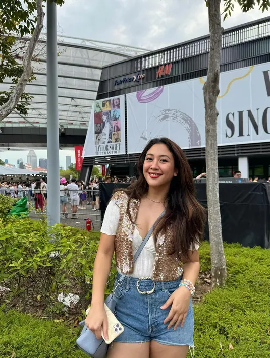 Padu padan outfit Sherina Munaf dengan top putih, sequined vest berwarna emas, dan denim shorts bisa masuk era 1989 dan Fearless nih. [@sherinamunaf]