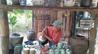 Nyai Fatimah sedang menyeduh kopi di pondok kopi dusun di Desa Muarajambi, Kecamatan Maro Sebo, Muaro Jambi, Jambi. (Liputan6.com/Gresi Plasmanto)