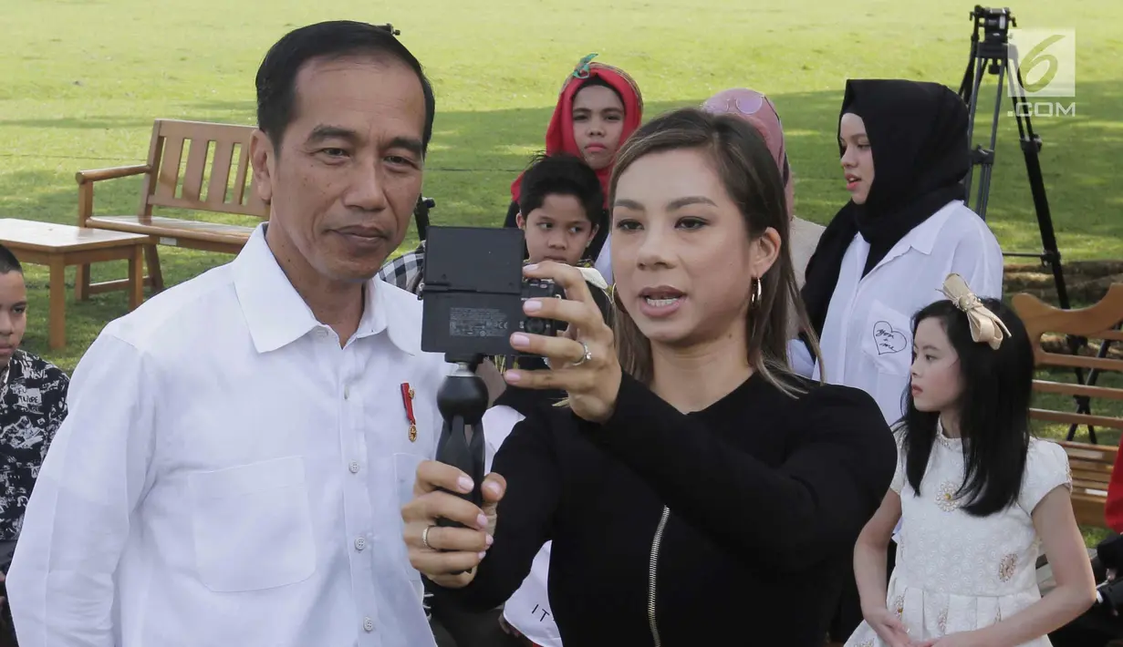 Presiden Joko Widodo bersama konten kreator XYZ 2018, Jennifer Bachdim di Istana Bogor, Minggu (22/4). Jokowi meminta tips untuk meningkatkan subscribe serta cara membuat vlog yang menarik. (Liputan6.com/Angga Yuniar)