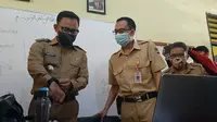 Wali Kota Bogor Bima Arya (kiri) sedang melakukan sidak ke SDN Genteng Kota Bogor, Senin (24/8/2020), untuk mengetahui kendala yang dihadapi guru maupun murid saat belajar daring selama pandemi Covid-19. (Liputan6.com/Achmad Sudarno)