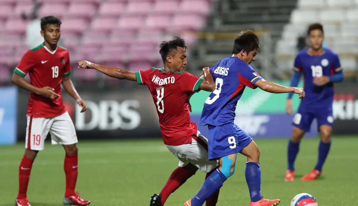 Pemain Indonesia U-23, M. Hargianto (kiri), berebut bola dengan pemain Filipina U-23, Paolo Bugas, dalam penyisihan Grup A Sepakbola SEA Games 2015 di Stadion Jalan Besar, Singapura. Selasa (9/6). (Bola.com/Arief Bagus)