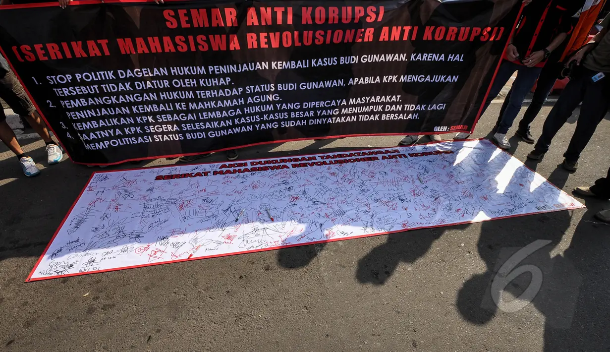 Massa membentangkan spanduk meminta KPK segera fokus menuntaskan kasus-kasus besar saat menggelar aksi di Bundaran HI, Minggu (4/4/2015). Padahal, Pemprov DKI melarang adanya kegiatan bernuansa politik selama CFD berlangsung. (Liputan6.com/Faizal Fanani)