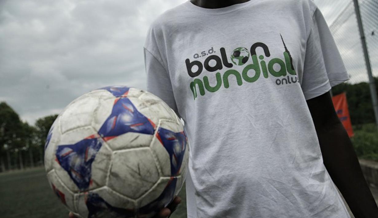 Salah satu sukarelawan dalam pertandingan antara Mali melawan Guinea dalam turnamen sepak bola untuk kaum migran dan orang asing bertajuk "Balon Mundial" yang dihelat 6 Juni-5 Juli 2015 di Turin, Italia. (AFP PHOTO/MARCO BERTORELLO)