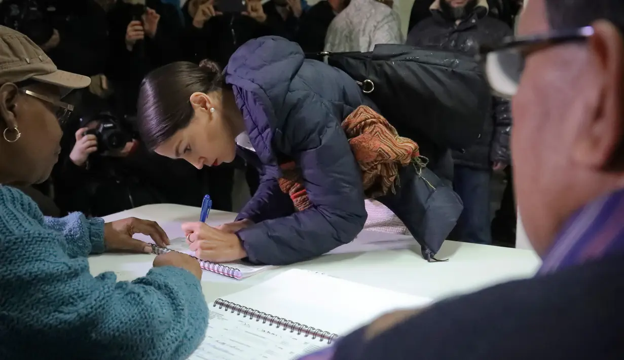 Calon anggota kongres Amerika Serikat (AS) Alexandria Ocasio-Cortez mendaftar saat pemungutan suara di komunitas Parkchester, Bronx, New York, Selasa (6/11). Ocasio-Cortez merupakan mantan pramusaji sebuah bar di New York. (AP Photo/Bebeto Matthews)