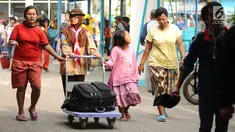 Seorang anggota Pramuka mendorong barang bawaan pemudik di kawasan Pelabuhan Merak, Banten, Kamis (22/6). Di Pelabuhan Merak, sejumlah anggota Pramuka diterjunkan untuk membantu pemudik membawa barang bawaan. (Liputan6.com/Helmi Fithriansyah)
