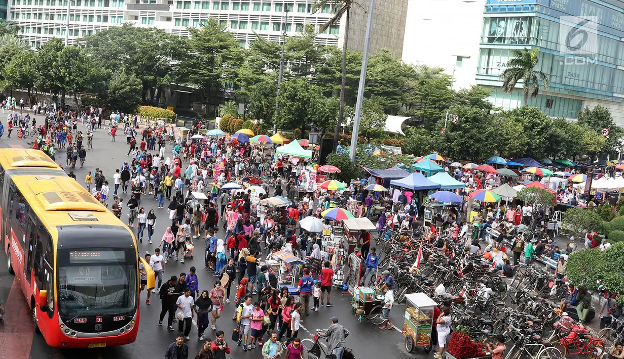 Sejumlah pedagang mencoba peruntungan dengan berjualan saat pelaksanaa CFD di Jalan Jendral Sudirman dan MH Thamrin, Jakarta, Minggu (11/2). Meski sempat diguyur hujan, warga tetap antusias beraktivitas. (Liputan6.com/Immanuel Antonius)