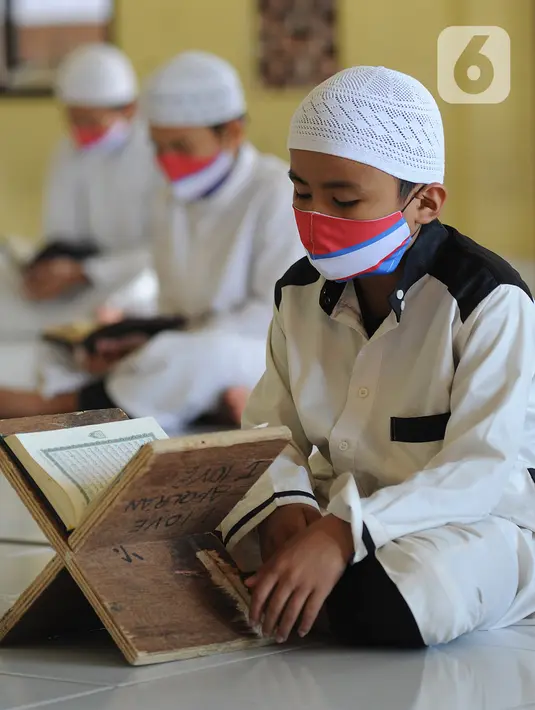 Santri berusia belasan tahun membaca Al quran atau tadarus bersama-sama dengan menerapkan jaga jarak di Masjid Daarul Qu'ran Pesantren Al Kautsar, Cibinong, Bogor, Kamis (7/5/2020). Kegiatan Khatam Al quran tersebut dilakukan rutin di setiap bulan Ramadan. (merdeka.com/Arie Basuki)